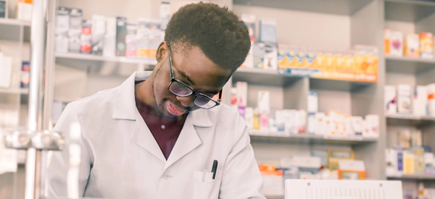 a man wearing a lab coat writing something down